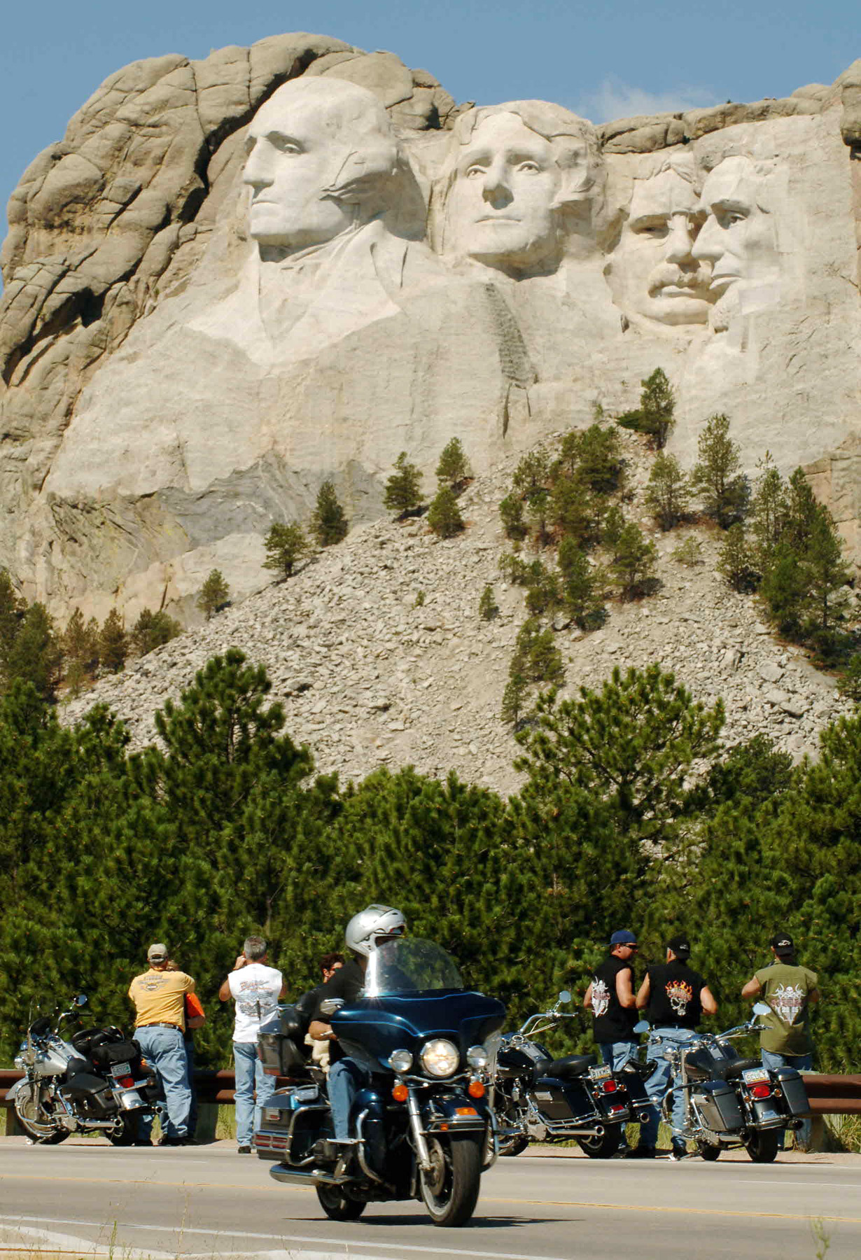 A rider leaves Mt. Rushmore, Sunday, August 7, 2005, as others stop on the shoulder to shoot photos.