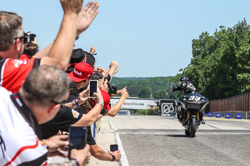 Kyle Wyman (#33) salutes the Harley-Davidson Screamin’ Eagle crew of factory engineers as he takes the checkered flag in the MotoAmerica King of the Baggers race at Road America.